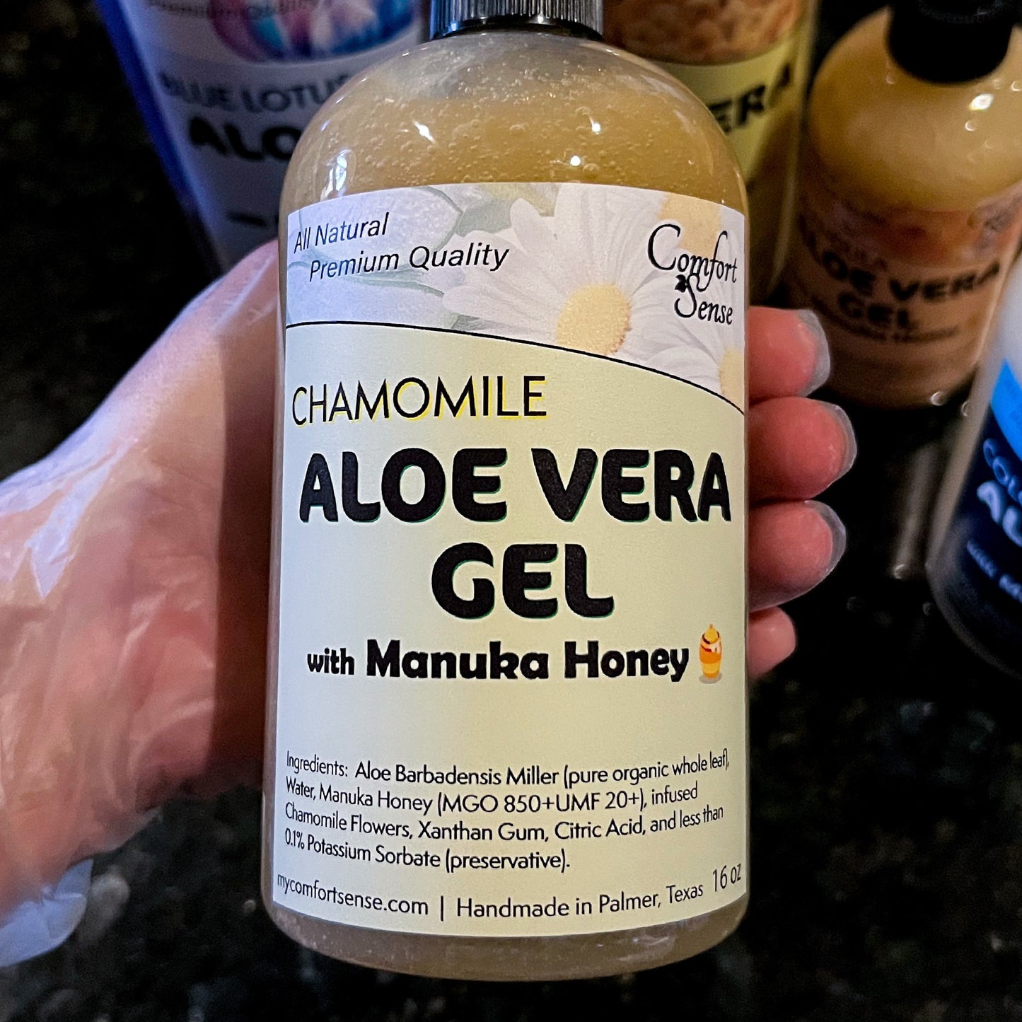 Bottle of Chamomile Aloe Vera Gel with Manuka Honey held by a hand.