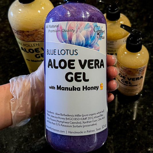 Bottle of Blue Lotus Aloe Vera Gel with Manuka Honey held by a person wearing gloves, with more aloe vera gel bottles in the background.
